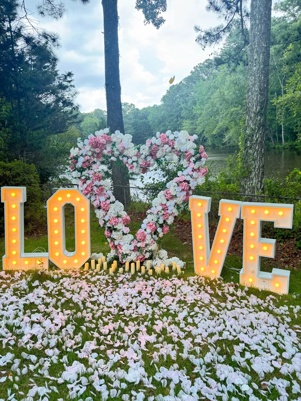 LOVE marquee letters with a floral heart at an outdoor celebration